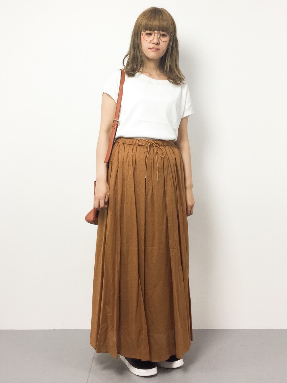 ホワイト系のニット/セーター、イエロー系のスカートを着用したレディースの春コーディネートの1枚目の写真