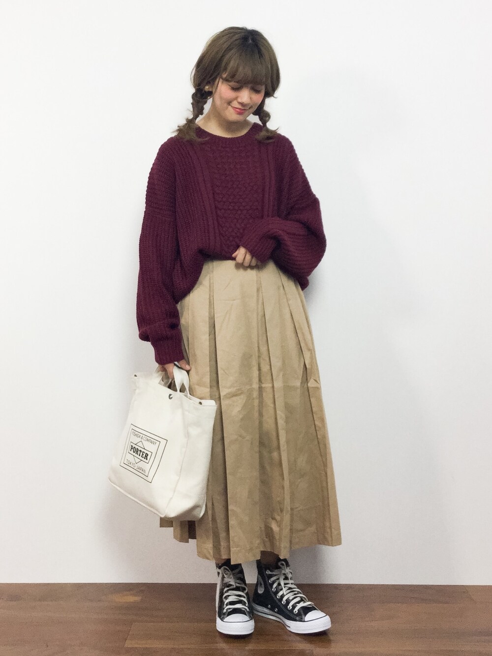 レッド系のニット/セーター、ホワイト系のスカートを着用したレディースの秋コーディネートの1枚目の写真