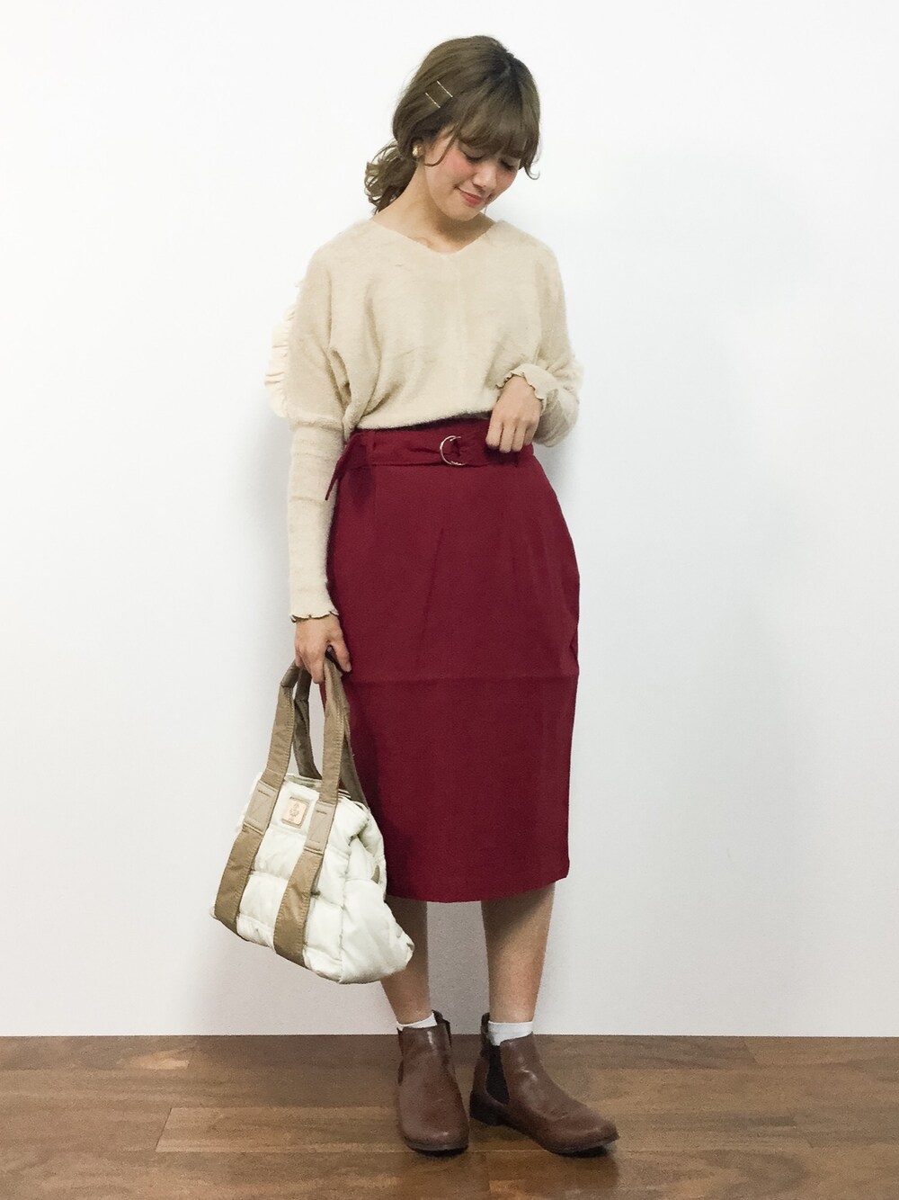 ベージュ系のニット/セーター、レッド系のスカート、ホワイト系のトートバッグを着用したレディースの秋コーディネートの1枚目の写真