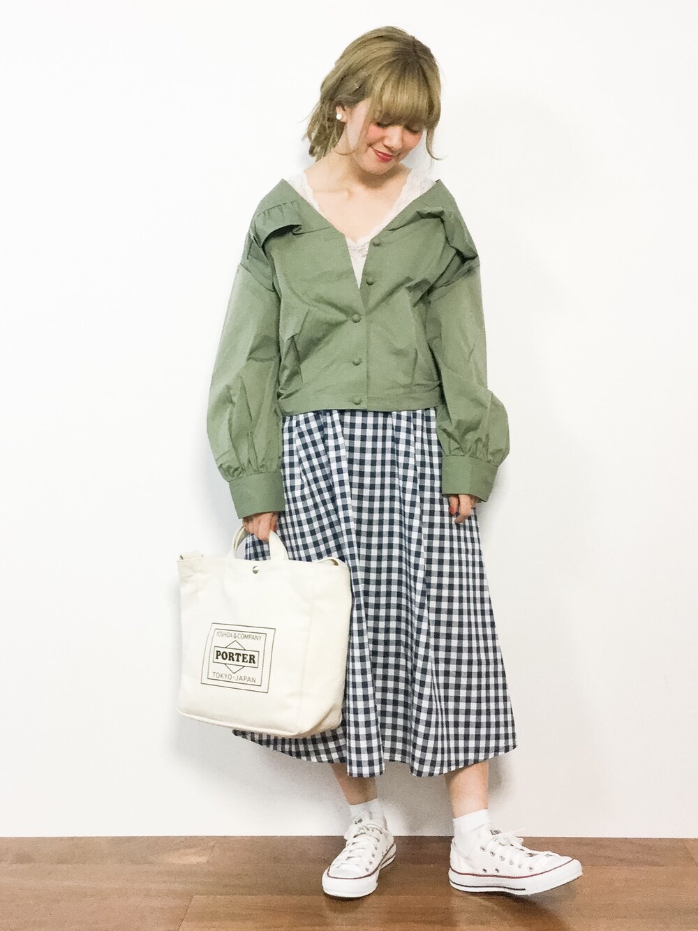 グリーン系のブルゾン、ブルー系のスカートを着用したレディースの春コーディネートの1枚目の写真