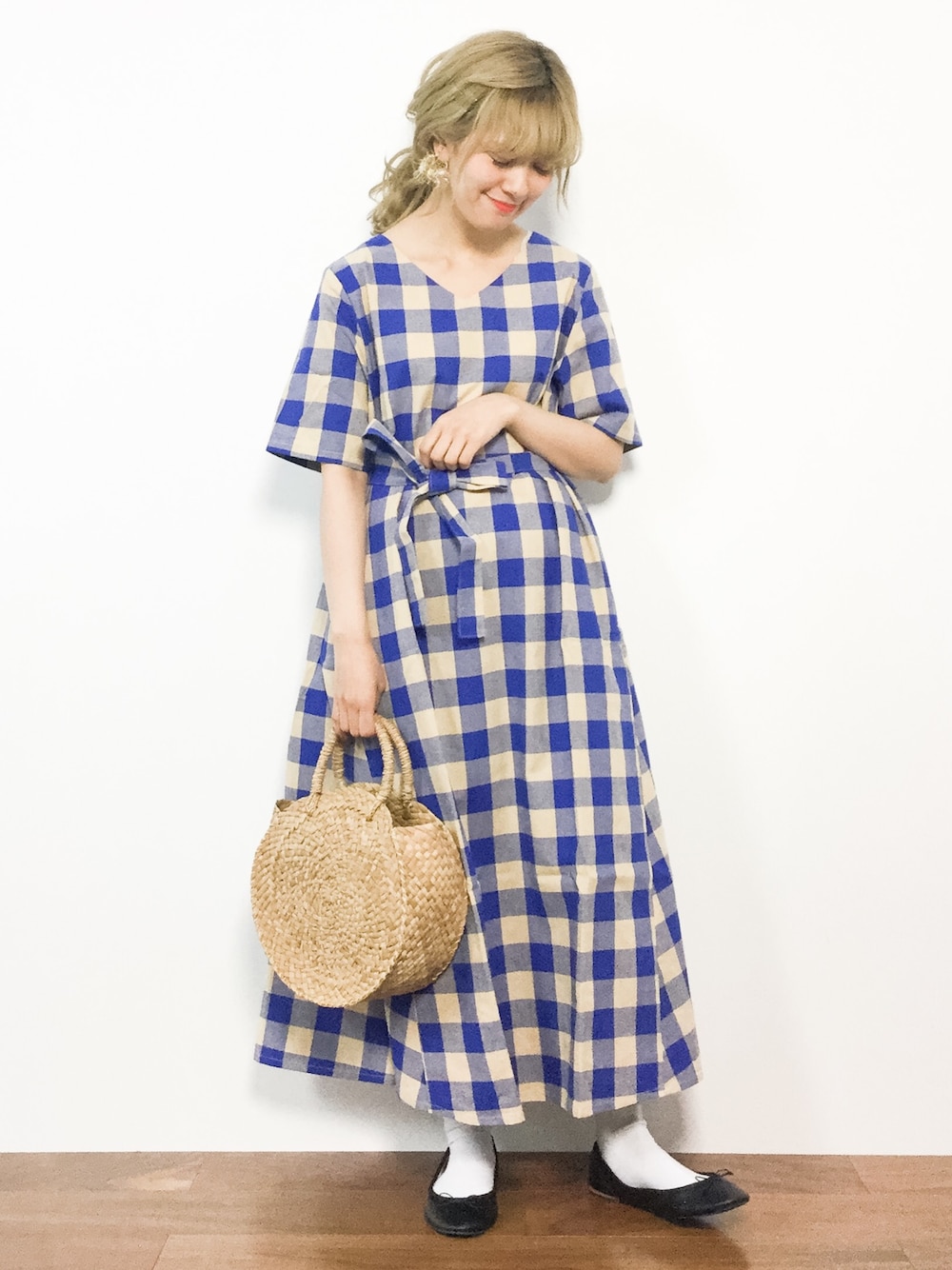 ブルー系のワンピース、ベージュ系のかごバッグを着用したレディースの春コーディネートの1枚目の写真