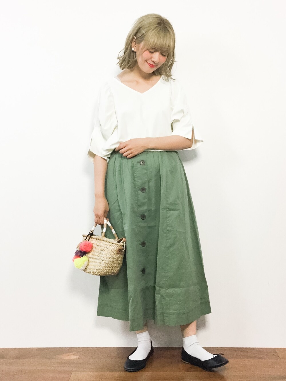 ホワイト系のシャツ/ブラウス、グリーン系のスカート、ベージュ系のかごバッグを着用したレディースの夏コーディネートの1枚目の写真