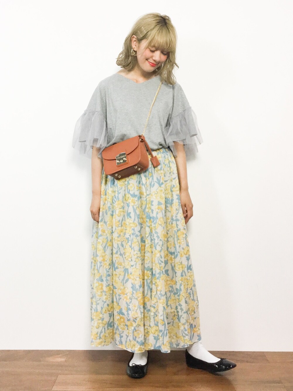 グレー系のTシャツ/カットソー、イエロー系のスカート、イエロー系のショルダーバッグを着用したレディースの夏コーディネートの1枚目の写真