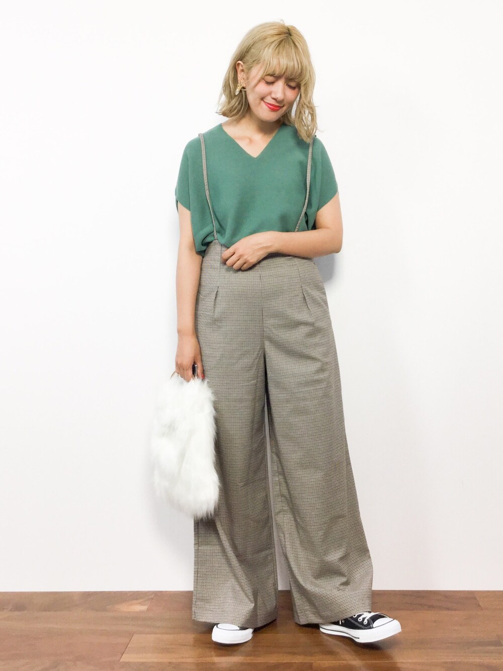 グリーン系のニット/セーター、ベージュ系のその他パンツ、ホワイト系のハンドバッグを着用したレディースの秋コーディネートの1枚目の写真