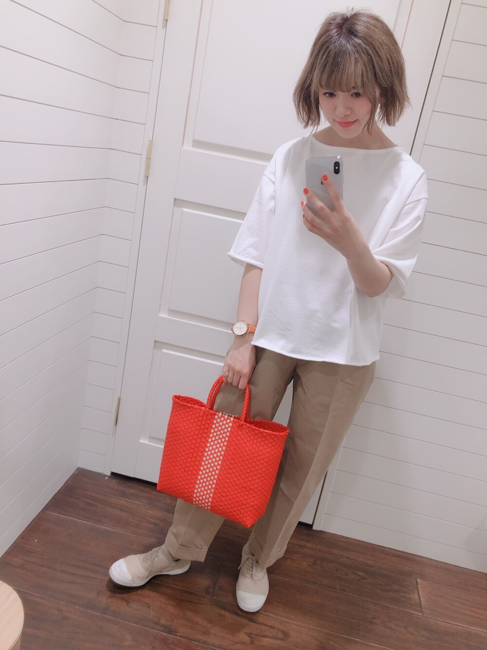 ホワイト系のTシャツ/カットソー、ベージュ系のパンツ、レッド系のかごバッグを着用したレディースの春コーディネートの1枚目の写真