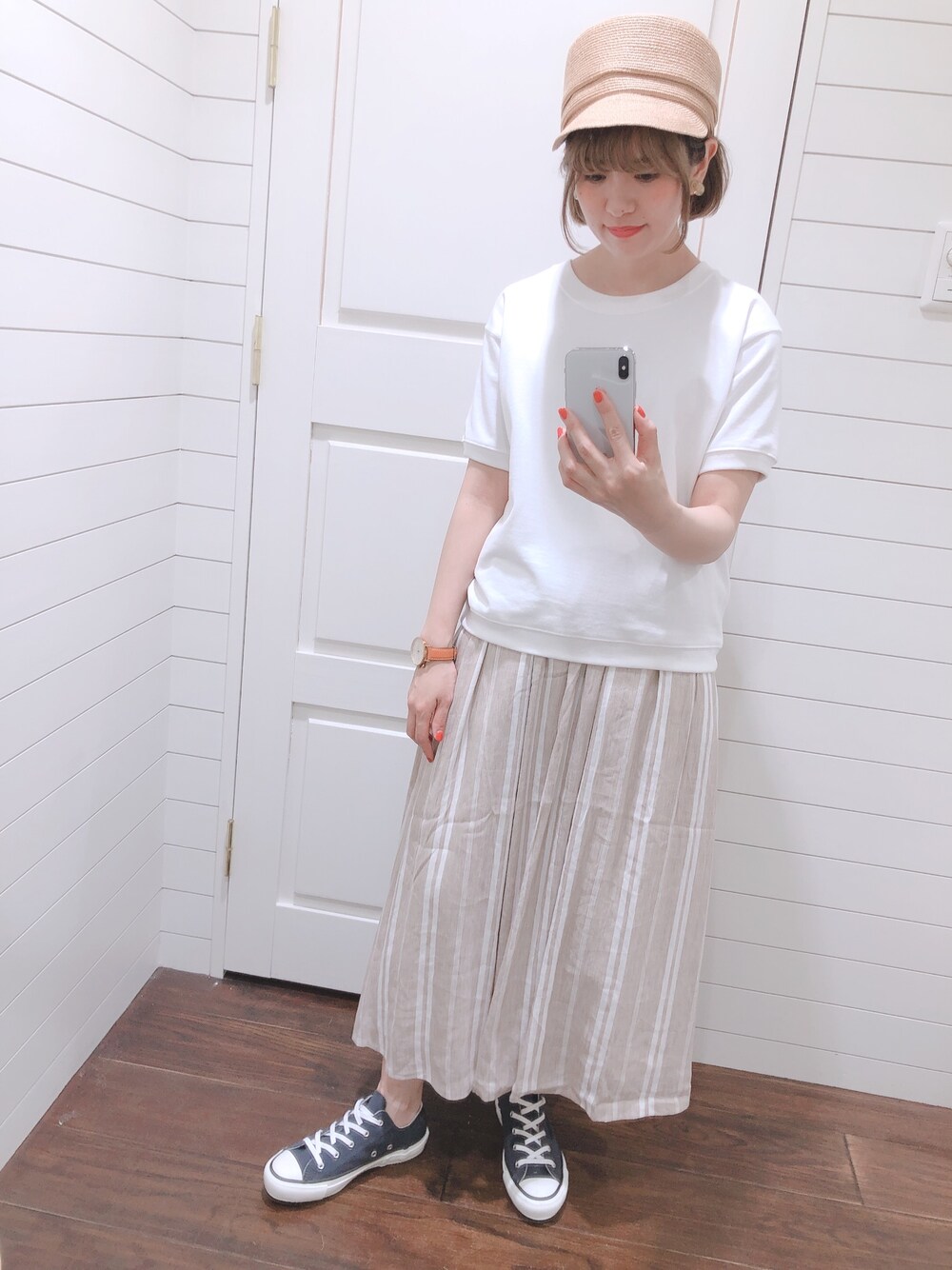 ホワイト系のTシャツ/カットソー、ベージュ系のスカート、ブルー系のスニーカーを着用したレディースの春コーディネートの1枚目の写真