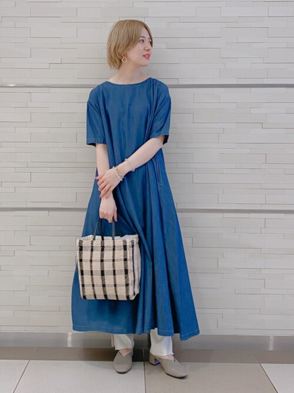 ブルー系のワンピース、ブラック系のハンドバッグ、グレー系のサンダルを着用したレディースの春コーディネートの1枚目の写真