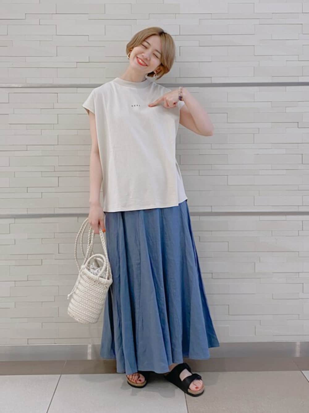 ホワイト系のTシャツ/カットソー、ブルー系のスカート、ホワイト系のショルダーバッグを着用したレディースの夏コーディネートの1枚目の写真