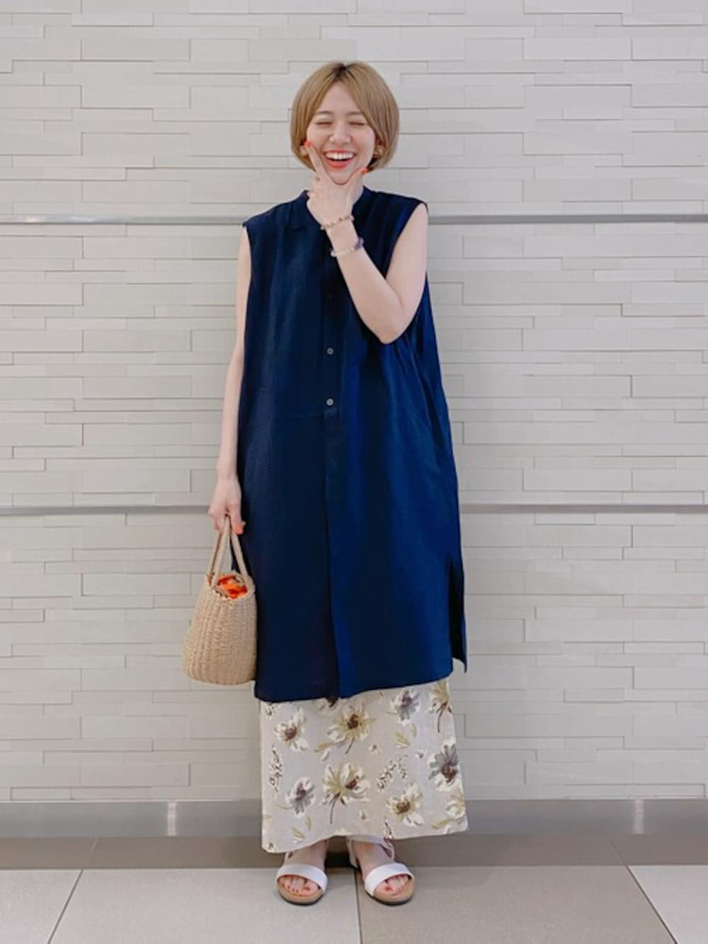 ブルー系のシャツ/ブラウス、イエロー系のスカート、オレンジ系のハンドバッグを着用したレディースの夏コーディネートの1枚目の写真