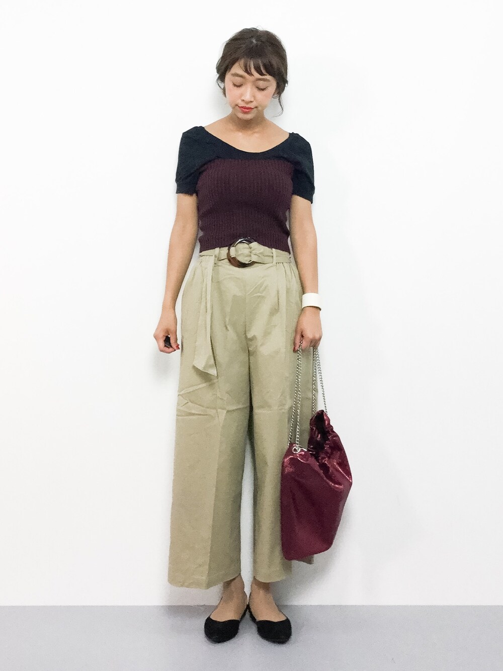 ベージュ系のチノパンツ、レッド系のベスト、レッド系のショルダーバッグを着用したレディースの夏コーディネートの1枚目の写真