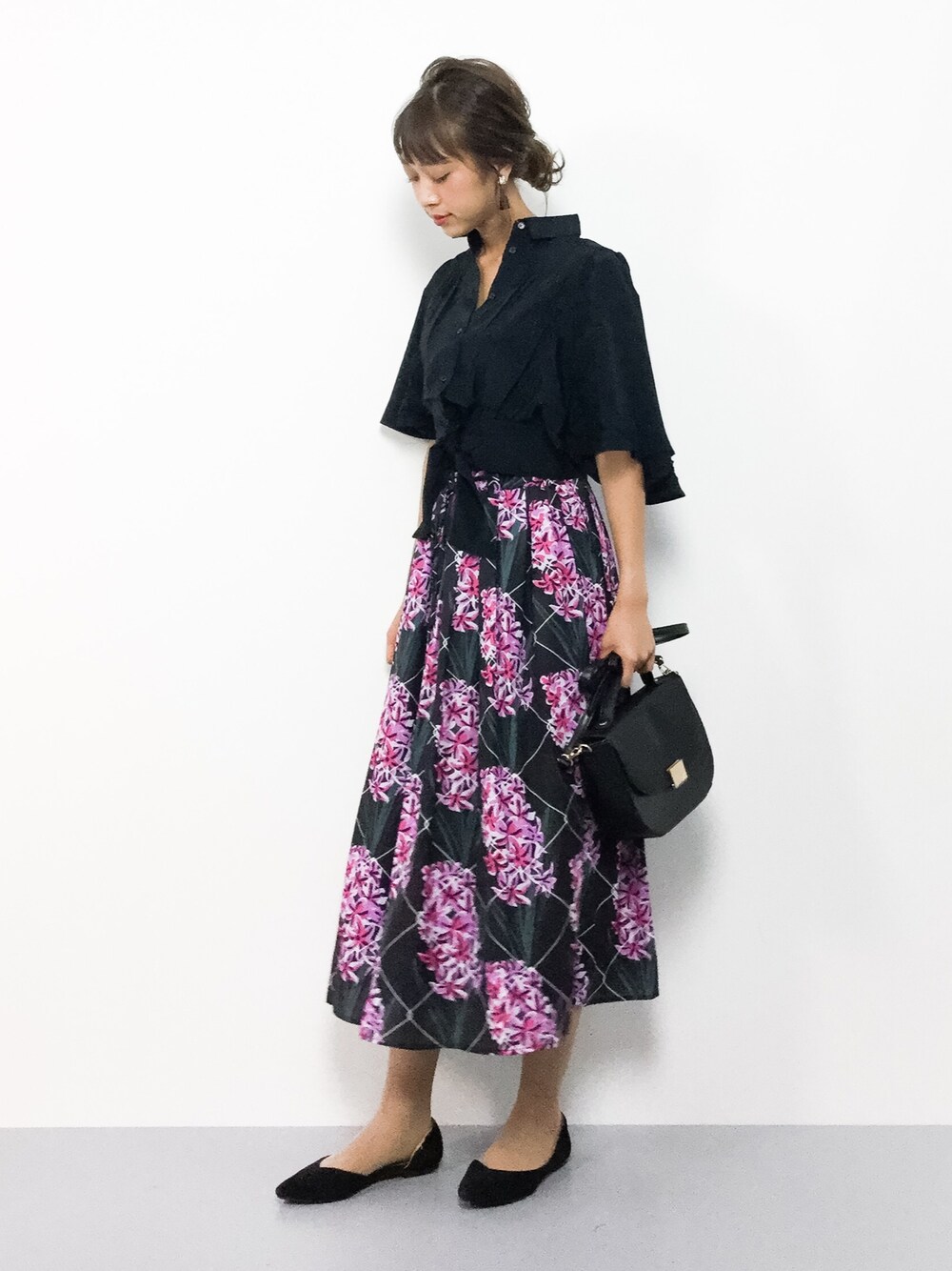 ブラック系のスカート、ブラック系のシャツ/ブラウス、ブラック系のショルダーバッグを着用したレディースの夏コーディネートの1枚目の写真