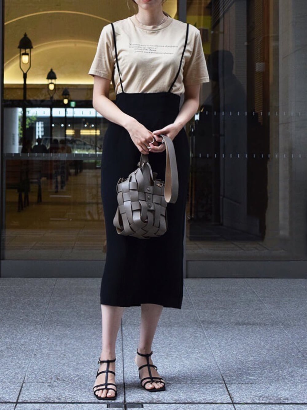 ベージュ系のTシャツ/カットソー、ブラック系のスカート、ブラウン系のショルダーバッグを着用したレディースの春コーディネートの1枚目の写真