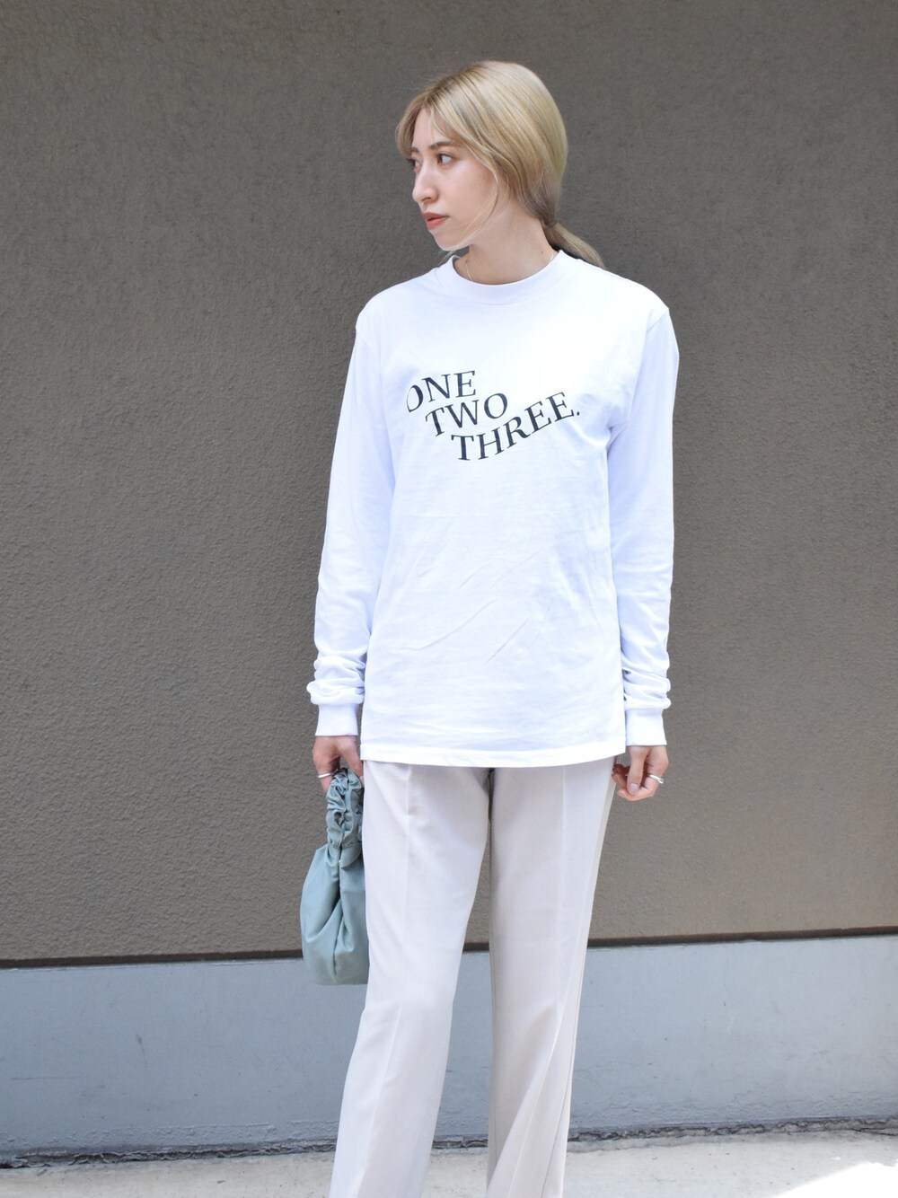 ホワイト系のTシャツ/カットソー、ホワイト系のその他パンツ、グリーン系のバッグを着用したレディースの春コーディネートの1枚目の写真