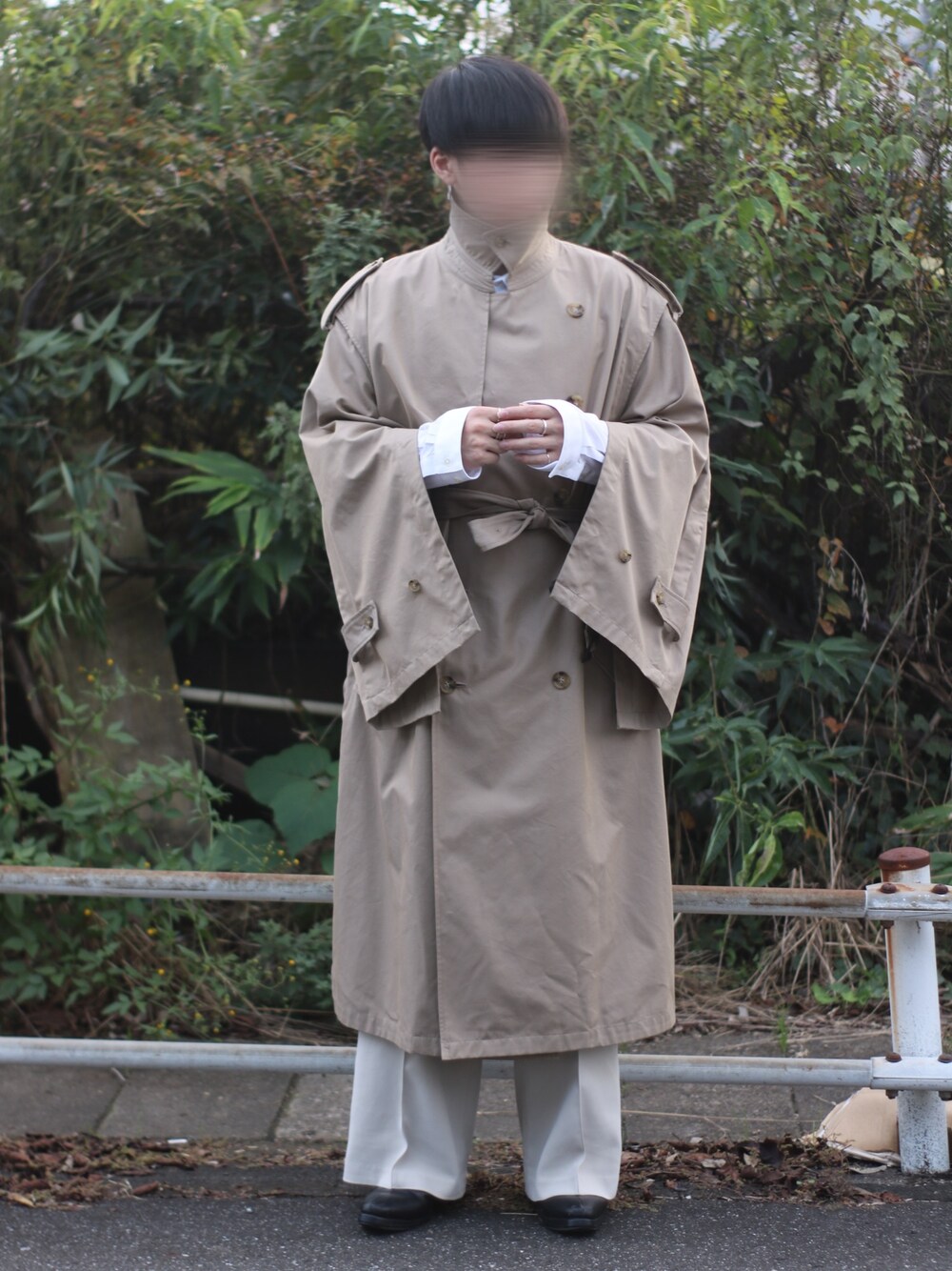 ベージュ系のトレンチコート、ホワイト系のシャツ/ブラウス、ベージュ系のパンツを着用したメンズの秋コーディネートの1枚目の写真