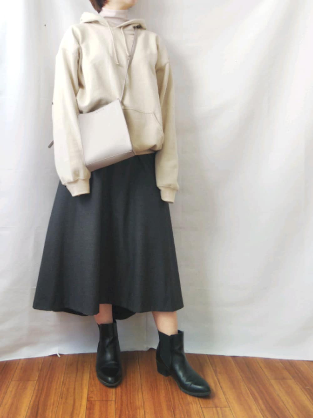 グレー系のショルダーバッグ、ベージュ系のパーカー、ベージュ系のTシャツ/カットソーを着用したレディースの冬コーディネートの1枚目の写真