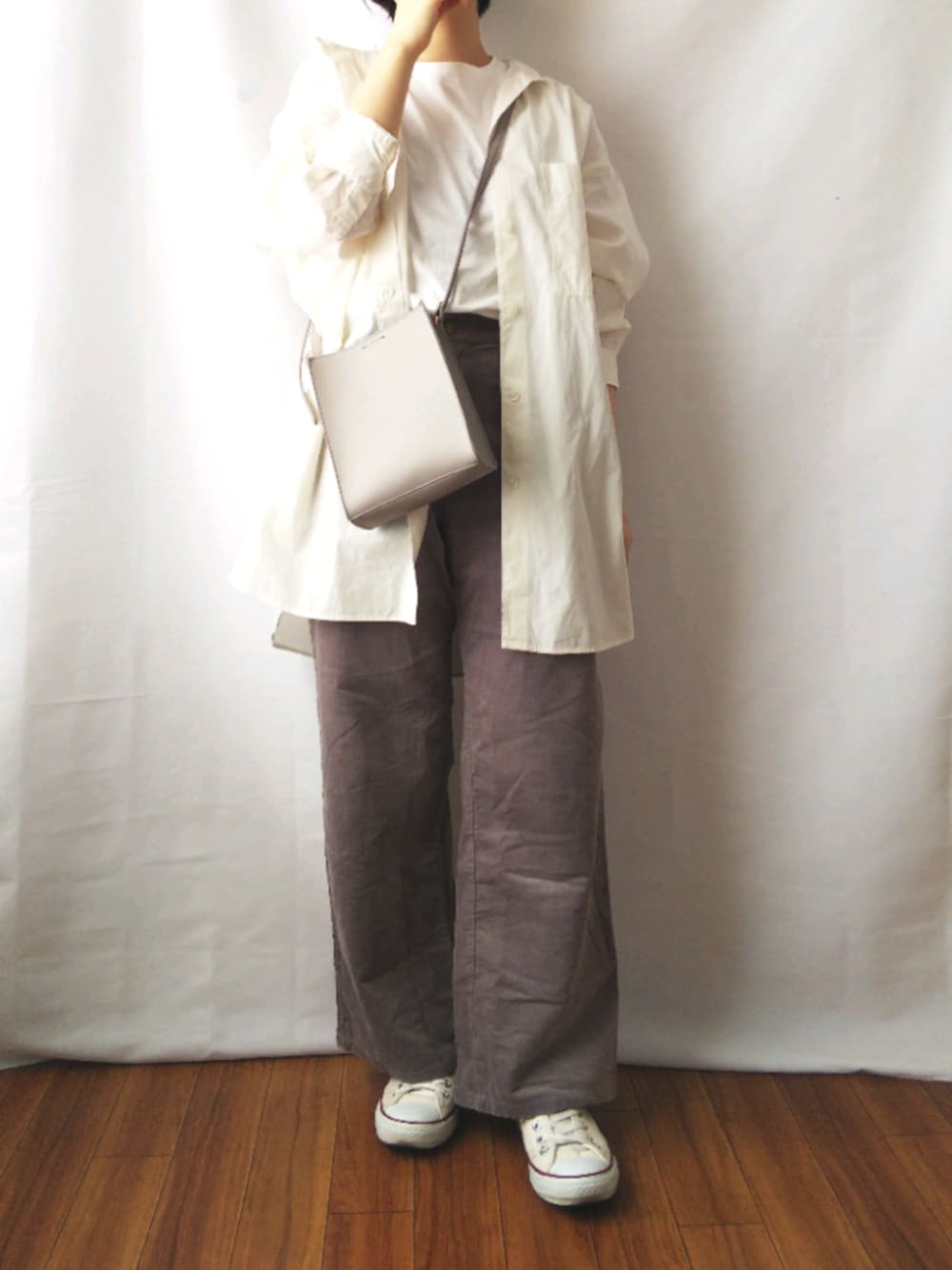 グレー系のパンツ、ホワイト系のシャツ/ブラウス、グレー系のショルダーバッグを着用したレディースの春コーディネートの1枚目の写真