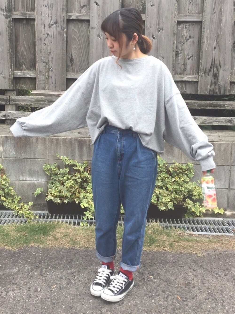 ブラック系のスニーカー、ブルー系のデニムパンツ、グレー系のTシャツ/カットソーを着用したレディースの春コーディネートの1枚目の写真