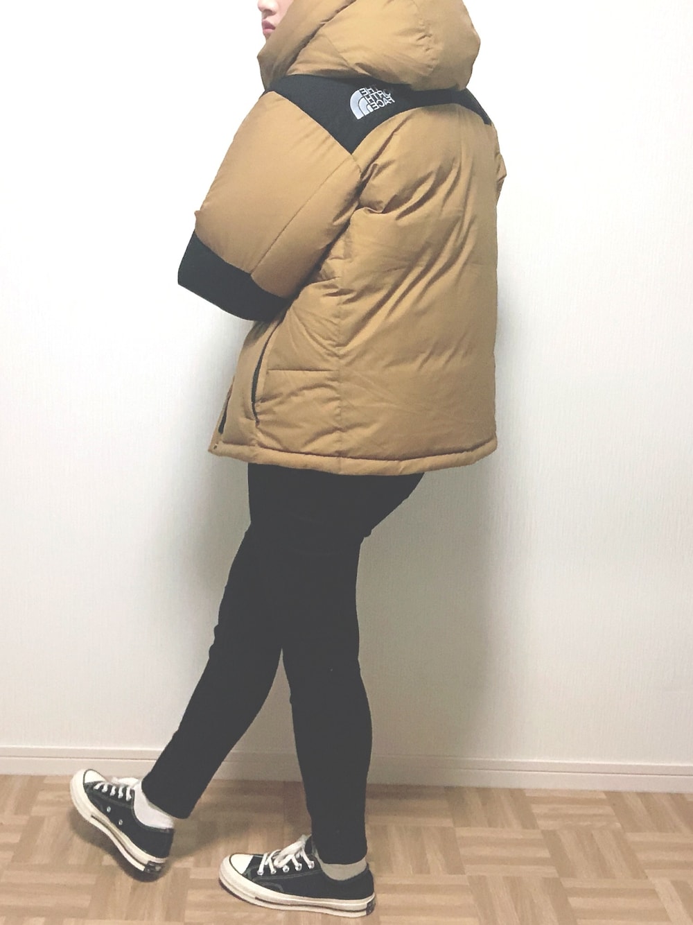 ベージュ系のダウンジャケット/コート、ブラック系のスニーカーを着用したレディースの冬コーディネートの1枚目の写真