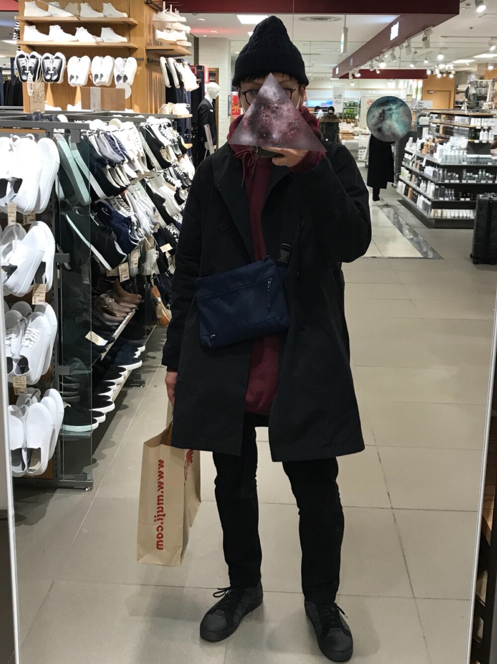 ブラック系のその他アウター、ホワイト系のパーカー、ブルー系のショルダーバッグを着用したメンズの冬コーディネートの1枚目の写真