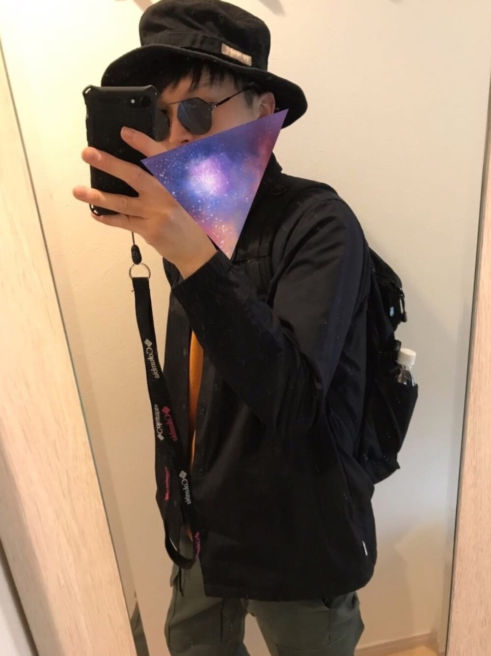 ブラック系のバックパック/リュック、パープル系のTシャツ/カットソー、グリーン系のカーゴパンツを着用したメンズの春コーディネートの1枚目の写真