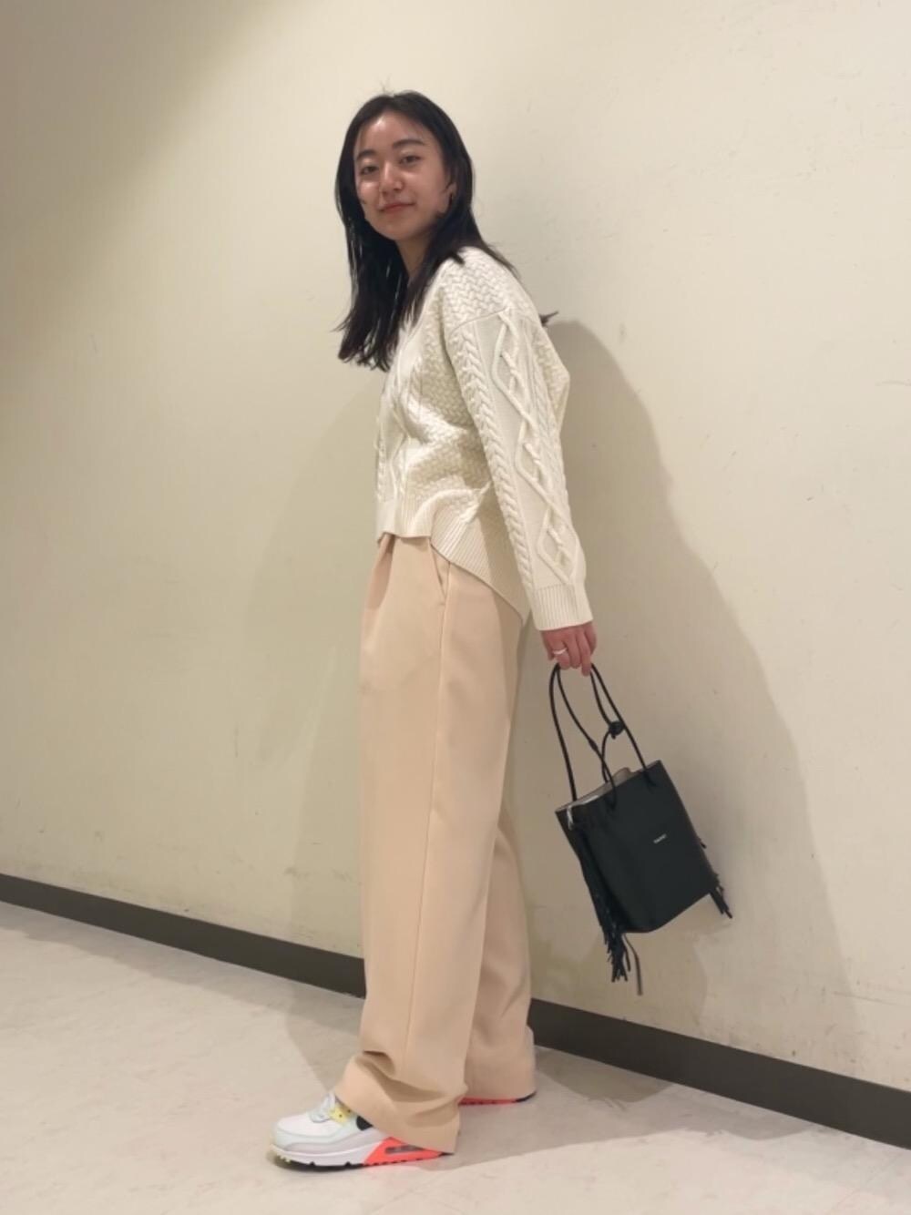 ホワイト系のニット/セーター、ベージュ系のその他パンツ、ブラック系のショルダーバッグを着用したレディースの冬コーディネートの1枚目の写真