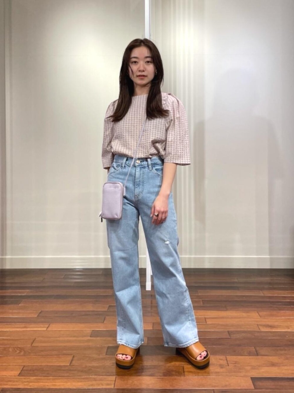 ブルー系のデニムパンツ、ブラウン系のサンダル、パープル系のシャツ/ブラウスを着用したレディースの春コーディネートの1枚目の写真