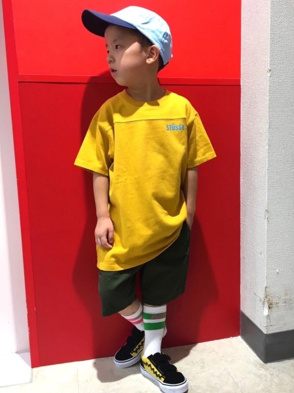 イエロー系のTシャツ/カットソー、イエロー系のスニーカー、ブルー系のキャップを着用したキッズの夏コーディネートの1枚目の写真