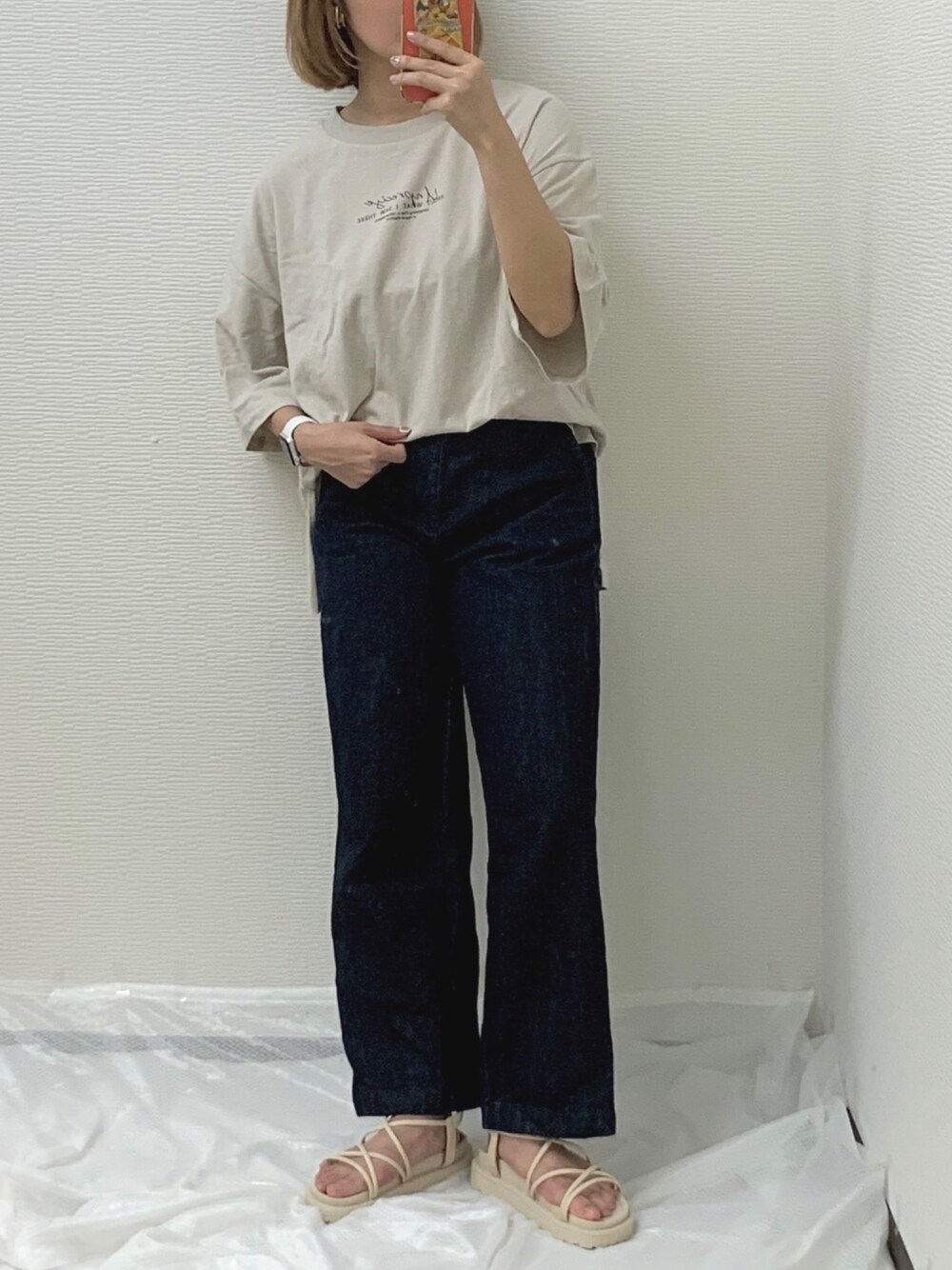 ベージュ系のTシャツ/カットソー、ブルー系のデニムパンツ、ベージュ系のサンダルを着用したレディースの夏コーディネートの1枚目の写真