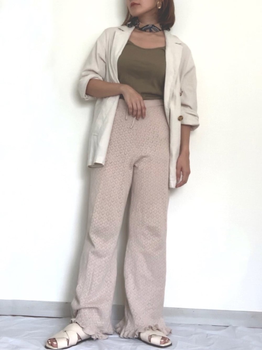 ベージュ系のその他パンツ、ホワイト系のテーラードジャケット、グリーン系のタンクトップを着用したレディースの秋コーディネートの1枚目の写真