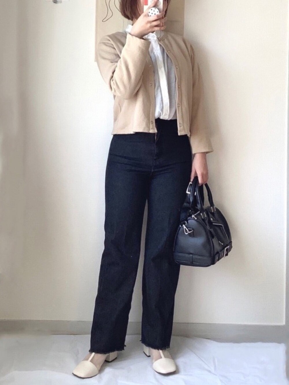 ホワイト系のシャツ/ブラウス、ベージュ系のカーディガン/ボレロ、ブラック系のデニムパンツを着用したレディースの春コーディネートの1枚目の写真
