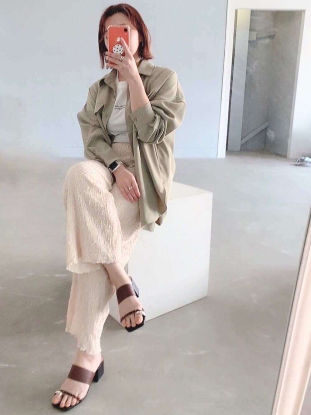 グリーン系のシャツ/ブラウス、ベージュ系のパンツ、ブラウン系のサンダルを着用したレディースの春コーディネートの1枚目の写真