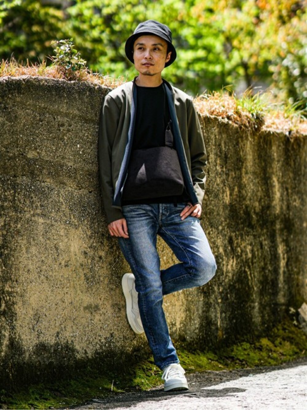 グリーン系のカーディガン/ボレロ、ブルー系のデニムパンツ、ホワイト系のスニーカーを着用したメンズの春コーディネートの1枚目の写真