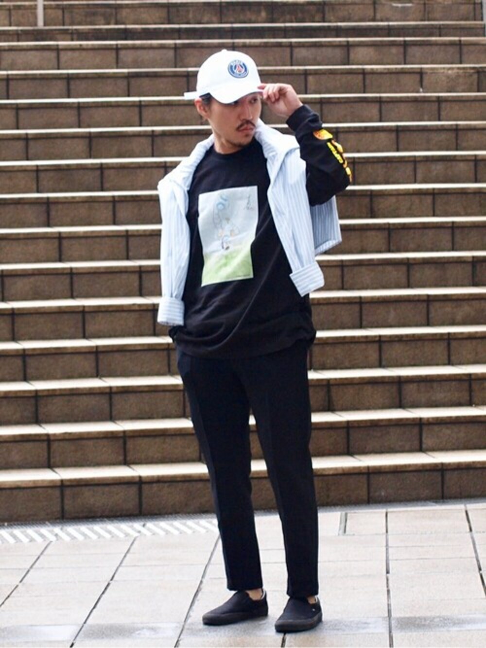 ブラック系のTシャツ/カットソー、ブラック系のその他パンツ、ホワイト系のキャップを着用したメンズの春コーディネートの1枚目の写真