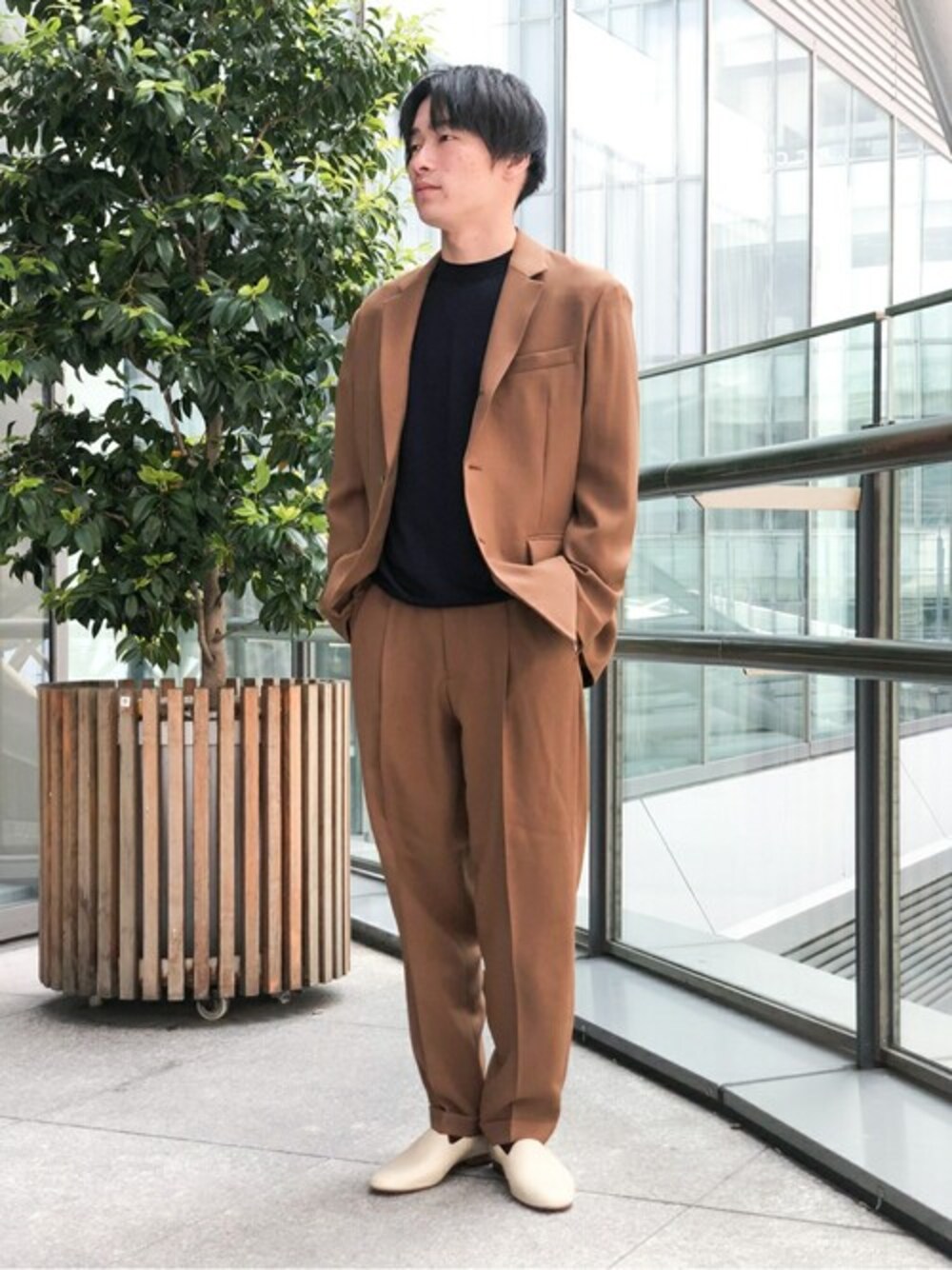 ブラウン系のテーラードジャケット、ブラウン系のその他パンツ、ブルー系のニット/セーターを着用したメンズの春コーディネートの1枚目の写真