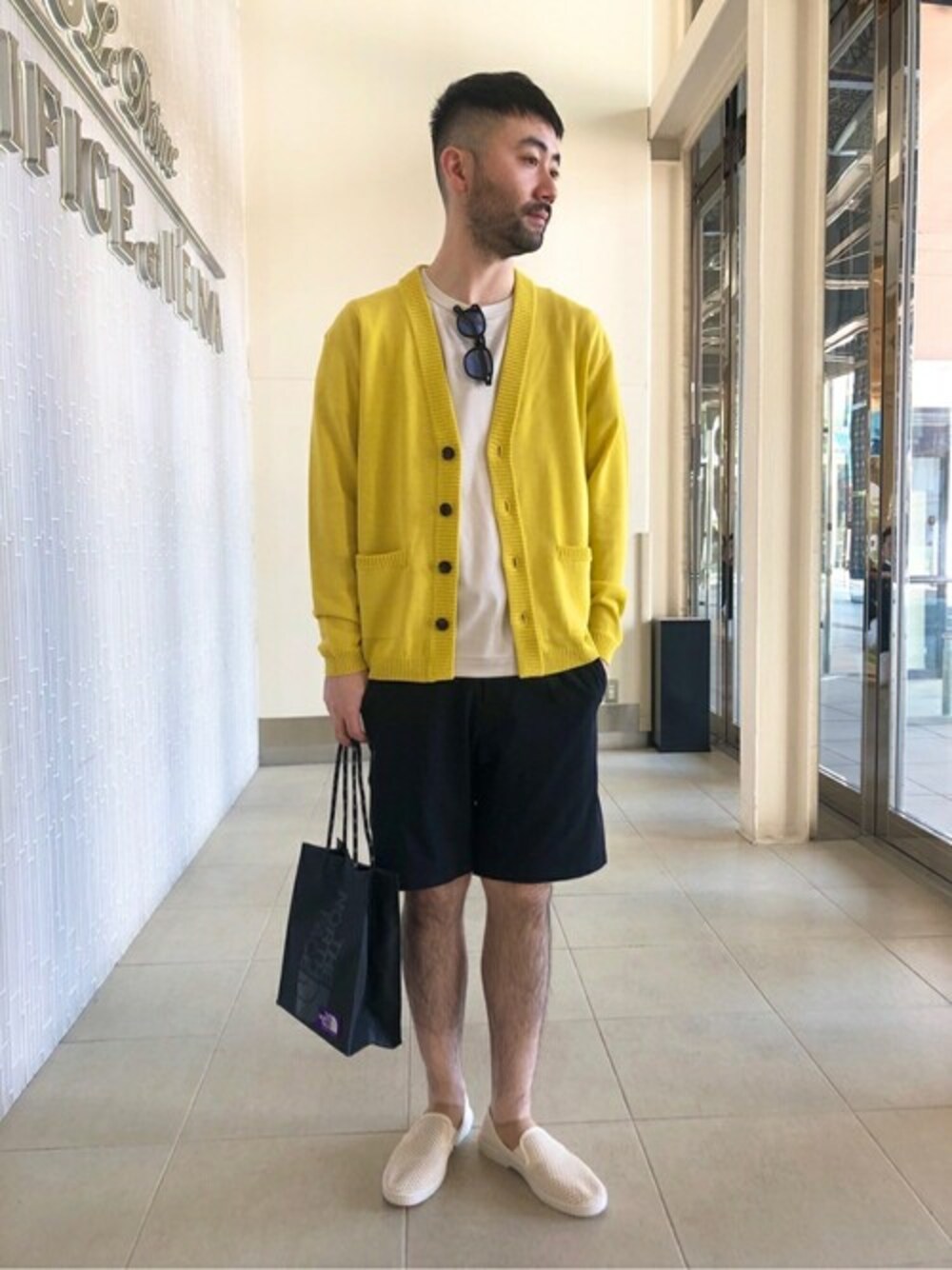 ブラック系のショルダーバッグ、ブラック系のその他パンツ、イエロー系のカーディガン/ボレロを着用したメンズの春コーディネートの1枚目の写真
