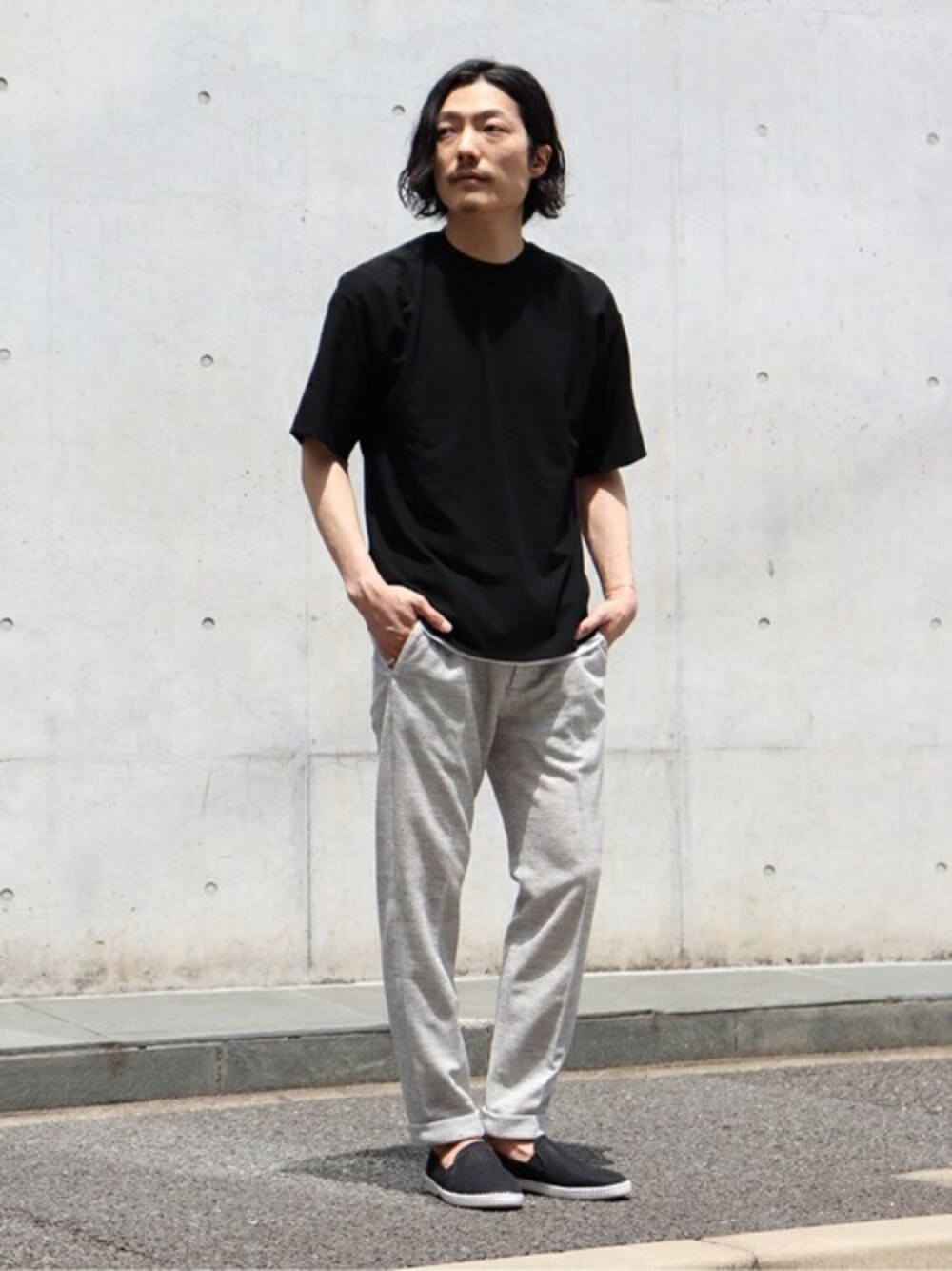 グレー系のその他パンツ、ブラック系のスリッポンを着用したメンズの春コーディネートの1枚目の写真