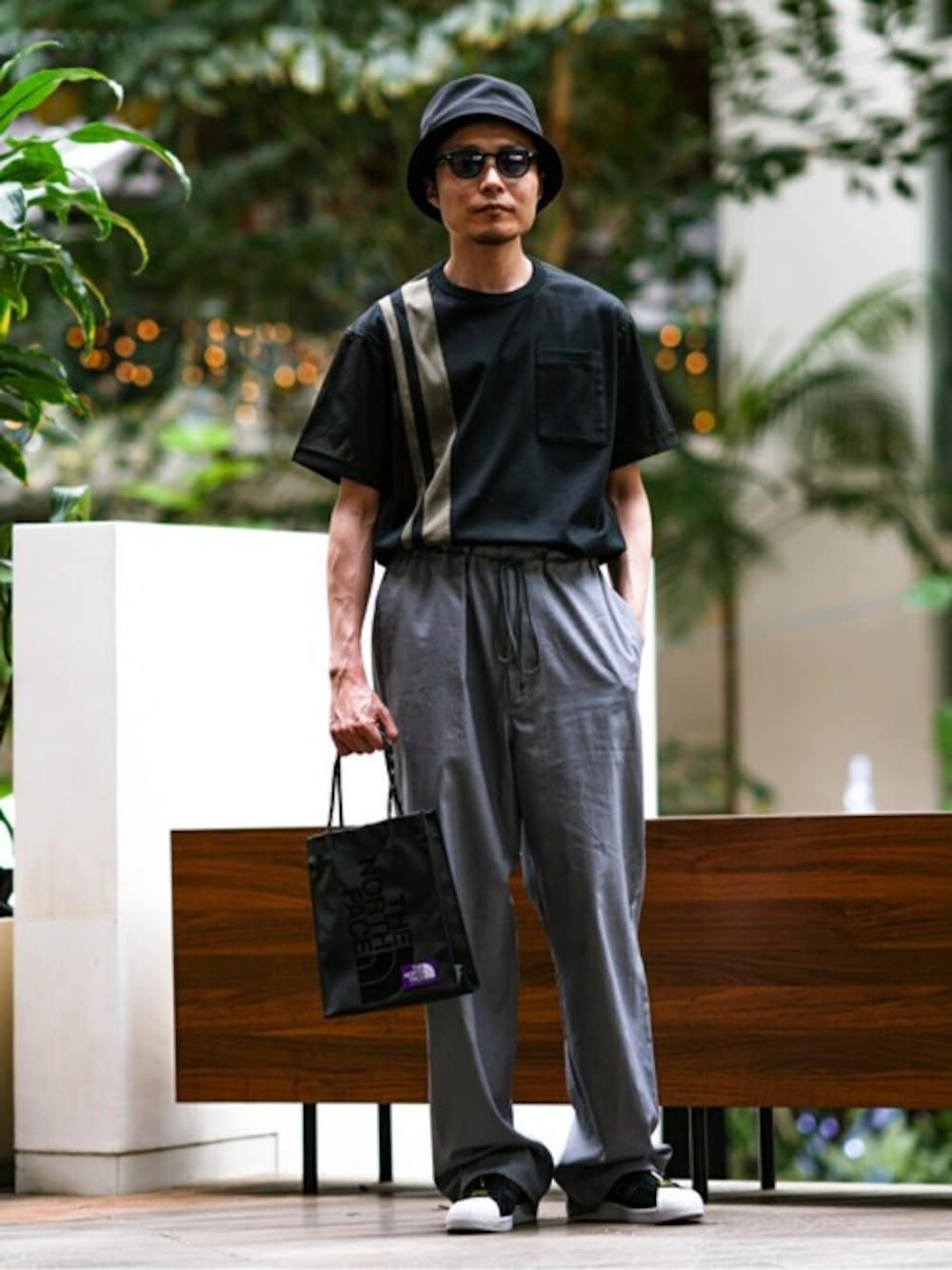 ブラック系のTシャツ/カットソー、ブラック系のスニーカー、ブラック系のショルダーバッグを着用したメンズの春コーディネートの1枚目の写真