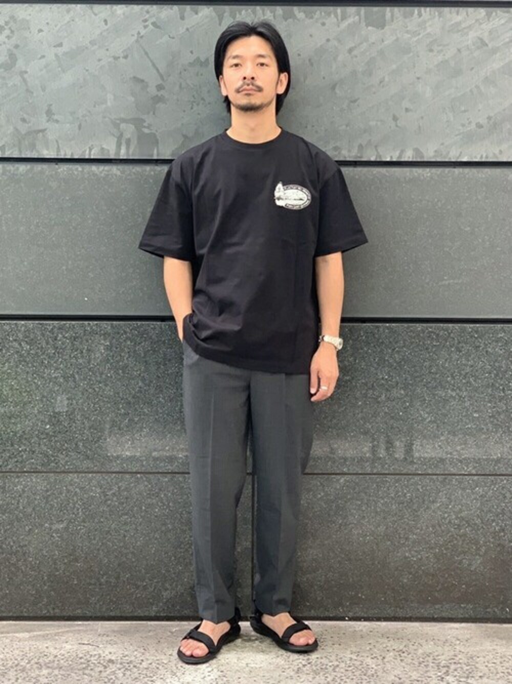 ブラック系のTシャツ/カットソー、グレー系のその他パンツ、ブラック系のサンダルを着用したメンズの夏コーディネートの1枚目の写真