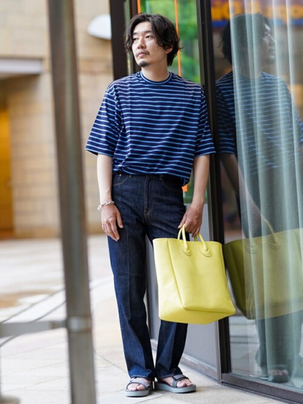 ブルー系のTシャツ/カットソー、グレー系のサンダル、イエロー系のトートバッグを着用したメンズの夏コーディネートの1枚目の写真