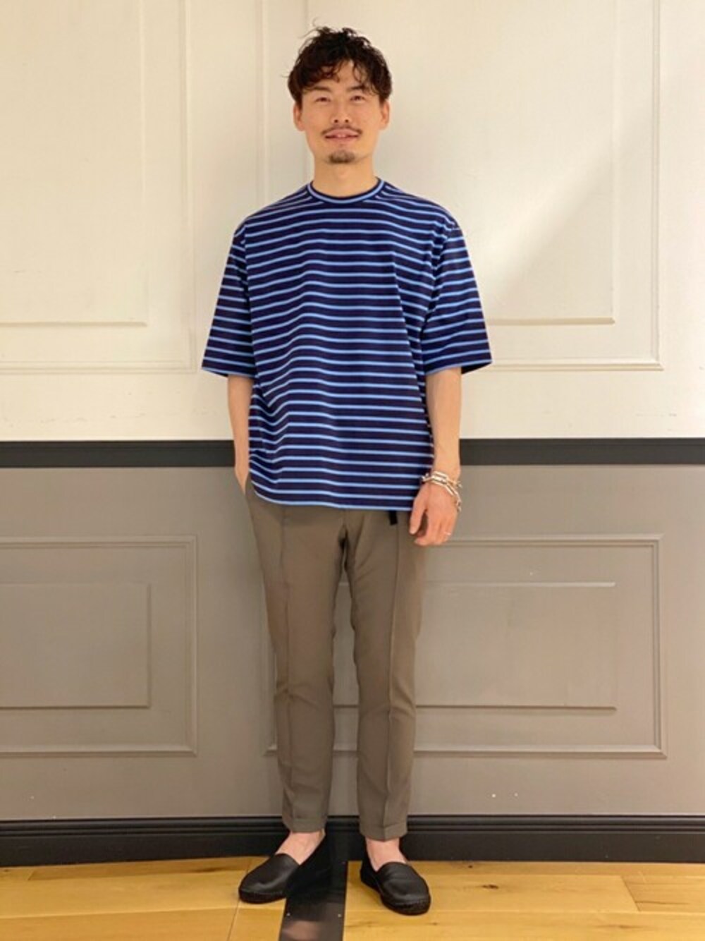 ブルー系のTシャツ/カットソー、グリーン系のその他パンツ、ブラック系のスリッポンを着用したメンズの夏コーディネートの1枚目の写真