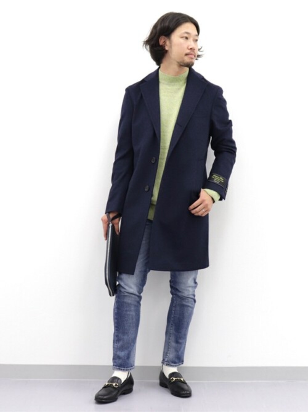 イエロー系のニット/セーター、ブルー系のデニムパンツ、ブラック系のドレスシューズを着用したメンズの秋コーディネートの1枚目の写真