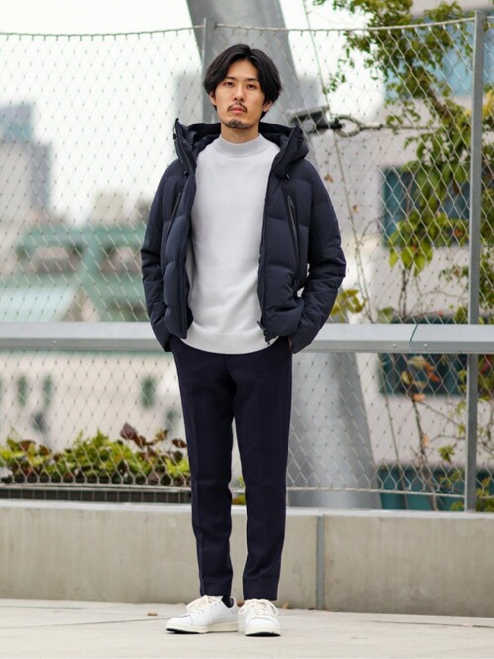 ブルー系のその他パンツ、ブルー系のダウンジャケット/コート、ホワイト系のニット/セーターを着用したメンズの冬コーディネートの1枚目の写真