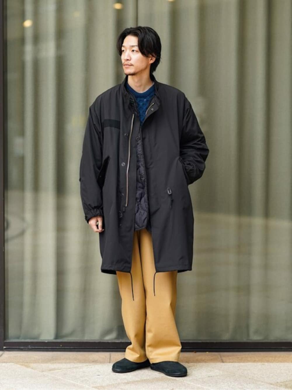 ブラック系のモッズコート、ブルー系のニット/セーター、イエロー系のその他パンツを着用したメンズの冬コーディネートの1枚目の写真