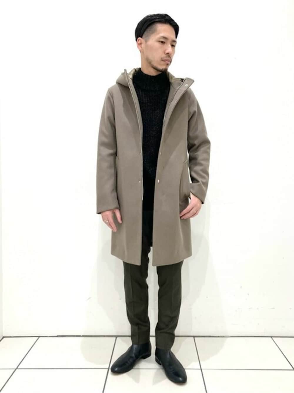 ベージュ系のダッフルコート、グリーン系のその他パンツ、ブラック系のブーツを着用したメンズの冬コーディネートの1枚目の写真