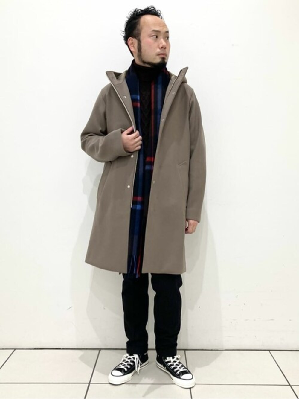 ベージュ系のダッフルコート、ブラウン系のニット/セーター、ブラック系のスニーカーを着用したメンズの冬コーディネートの1枚目の写真