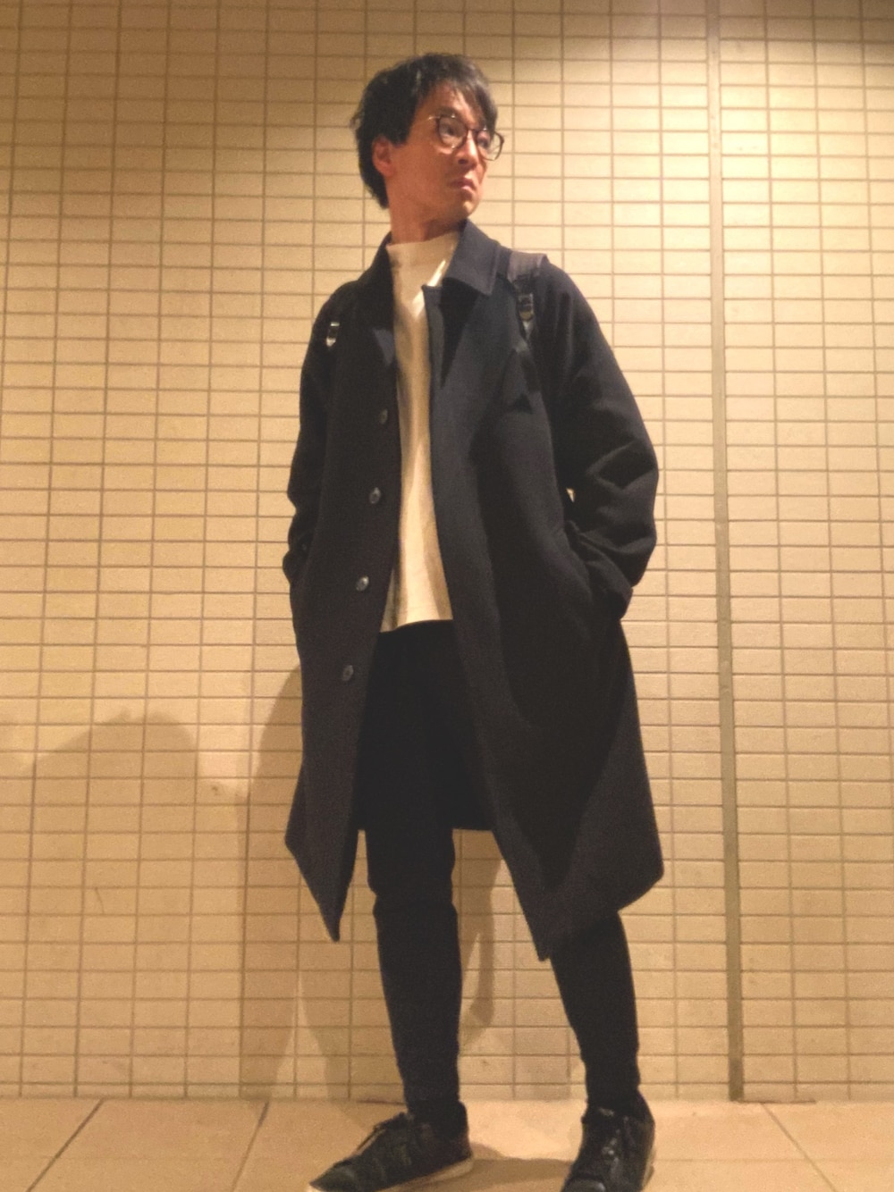 「シンプル、大人カジュアル、カジュアル、モノトーン、白スニーカー、スニーカーコーデ、ステンカラーコート、ジョガーパンツ、リュック、モックネック」｜「UNIQLOのアイテム（ステンカラーコート、ブラック系）」を使った、eiさん（メンズ・173cm）の冬コーディネートの1枚目の写真