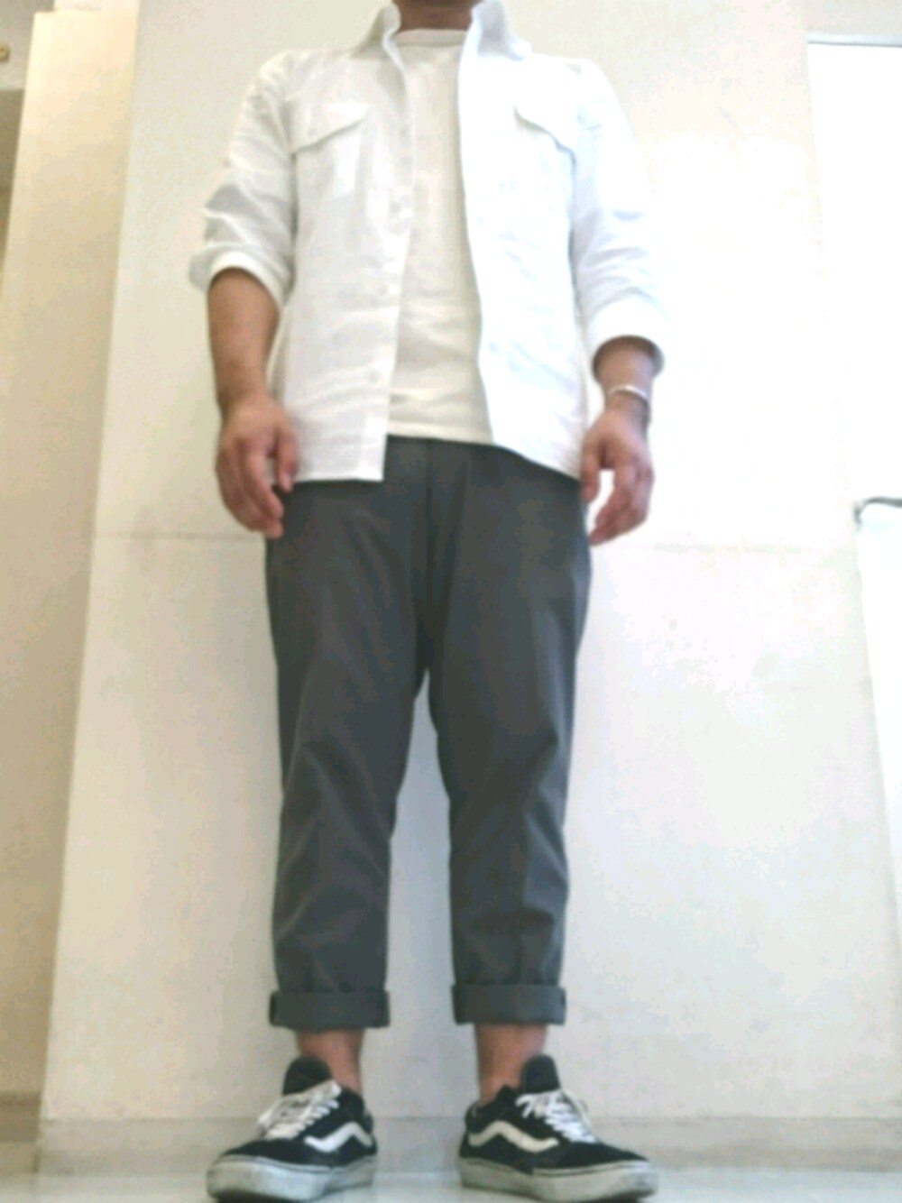 ブラック系のスニーカー、グリーン系のパンツ、ホワイト系のシャツ/ブラウスを着用したメンズの春コーディネートの1枚目の写真