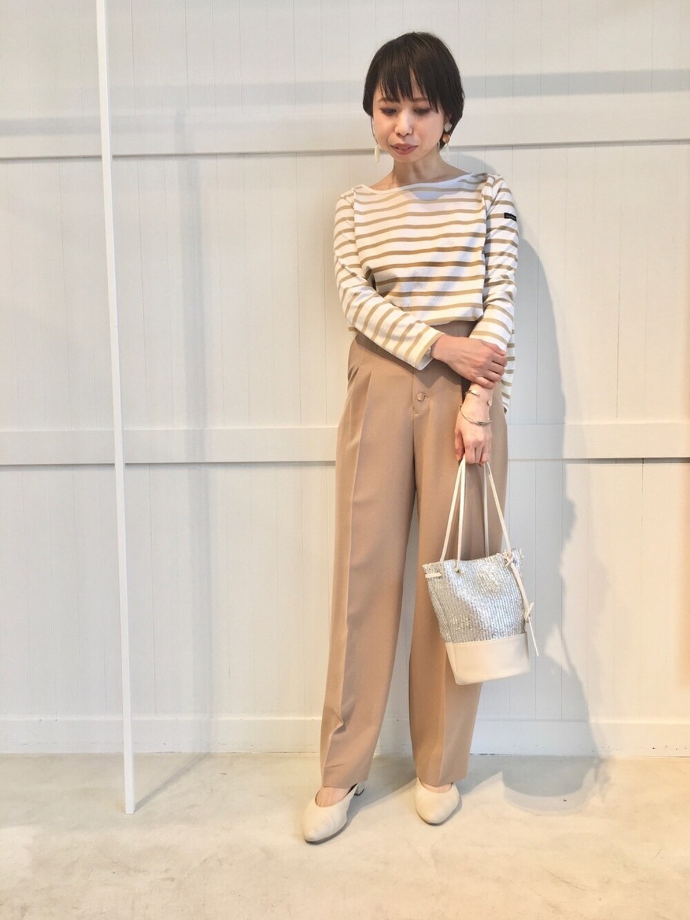 ベージュ系のパンツ、ベージュ系のTシャツ/カットソーを着用したレディースの春コーディネートの1枚目の写真
