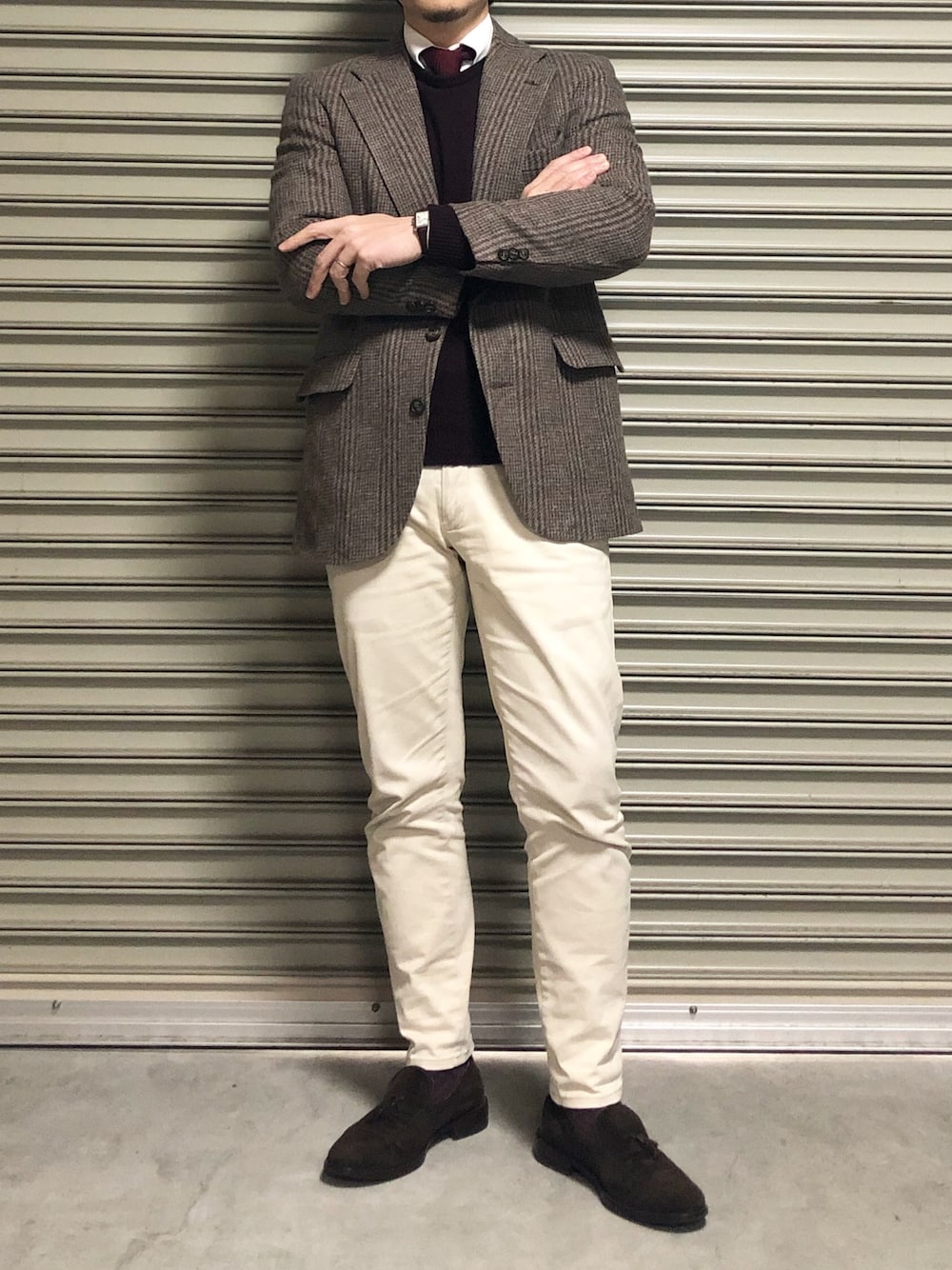 ベージュ系のチノパンツ、レッド系のニット/セーター、レッド系のネクタイを着用したメンズの冬コーディネートの1枚目の写真