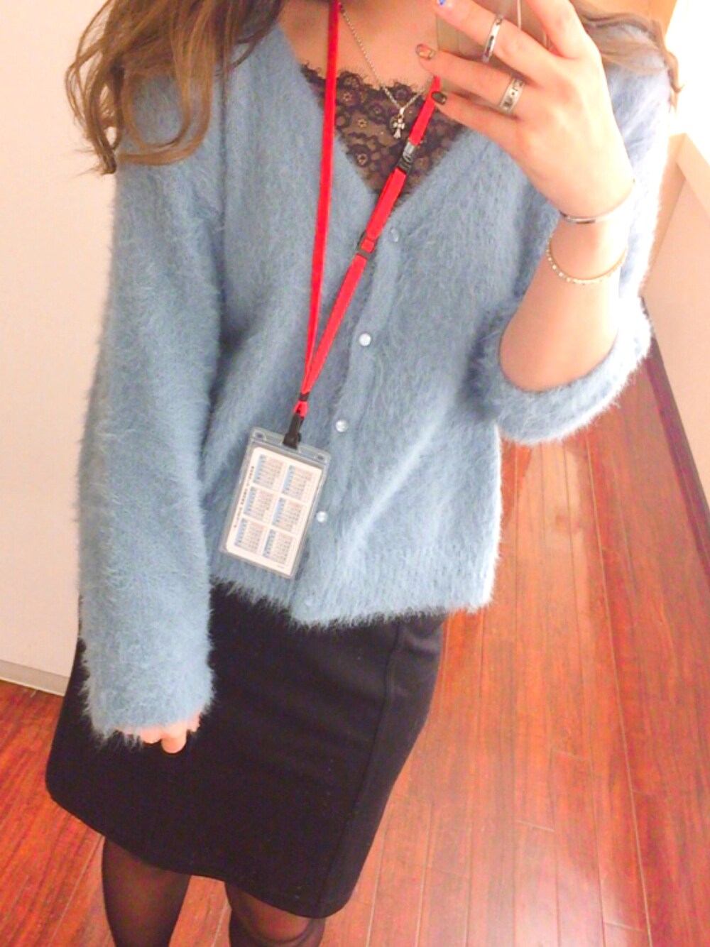 ブルー系のカーディガン/ボレロ、ブラック系のスカート、シルバー系のブレスレットを着用したレディースの冬コーディネートの1枚目の写真